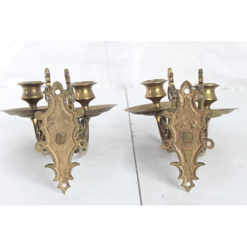 64 - A pair of decorative antique brass candle sconces.