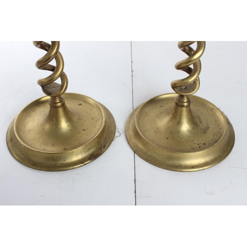 142 - A stunning pair of large twisted brass candlesticks, each measuring 20inches.