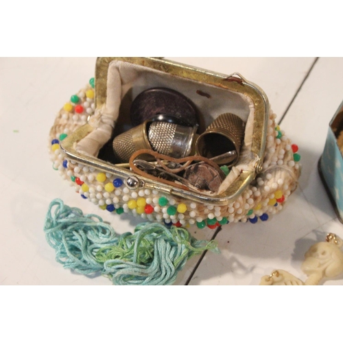 288 - A small vintage child's purse and tin containing thimbles, marbles and more.