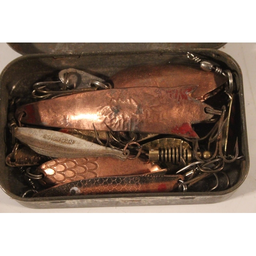 554 - A tin box of fishing lures.