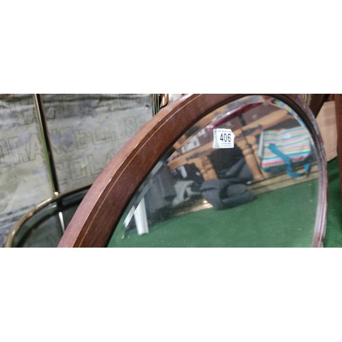 406 - An inlaid mahogany oval mirror.