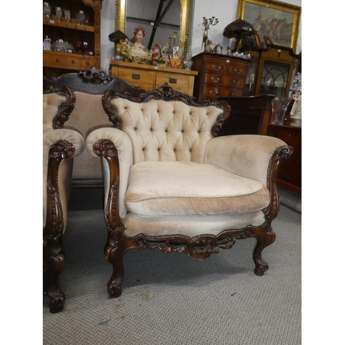 362 - A stunning antique style pair of armchairs with button back upholstery & decoratively carved frames.