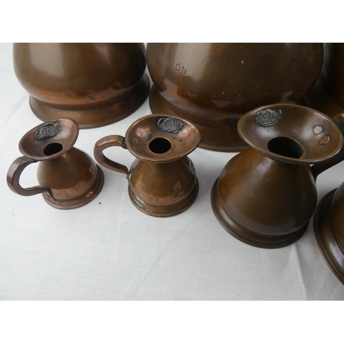 400 - A stunning collection of antique copper measuring jugs, from 2 gallons to 1/4 gill, each with variou... 