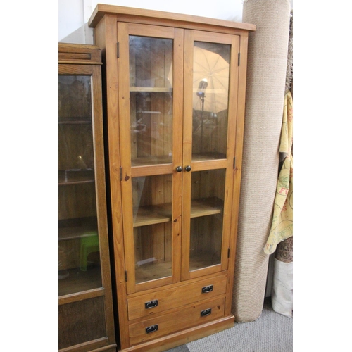 483 - A large modern bookcase with glass doors, measuring 31.5x11.5x73inches.