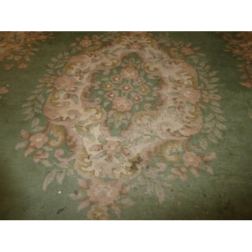 180 - A large green floral patterned rug, measuring