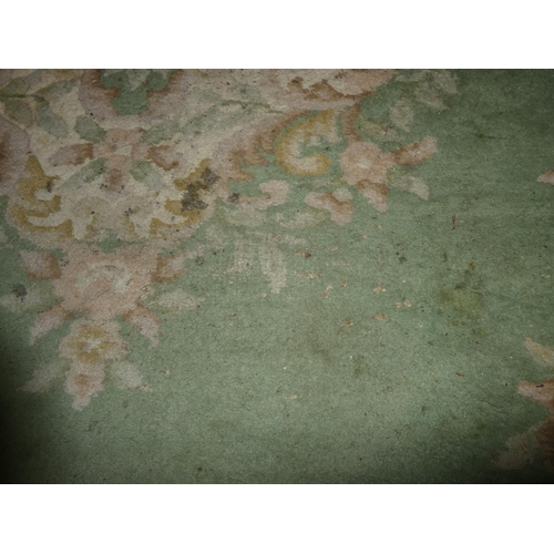 180 - A large green floral patterned rug, measuring