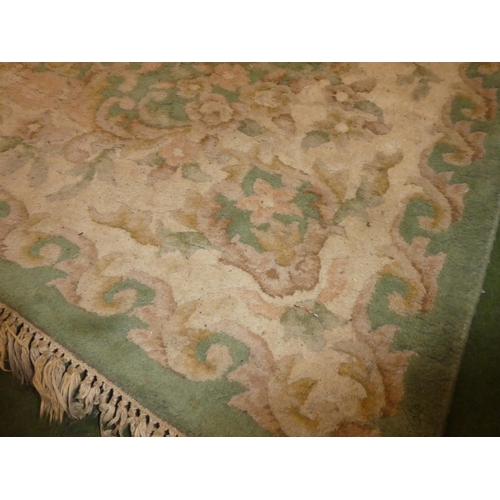 180 - A large green floral patterned rug, measuring