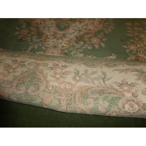 180 - A large green floral patterned rug, measuring