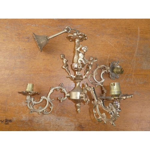 228 - A gilt metal three branch light fitting with decorative scrolls.