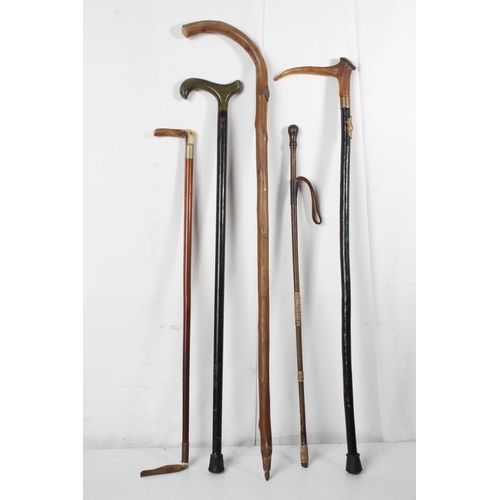 253 - Two vintage riding crops, a vintage horn handled walking cane and two others.