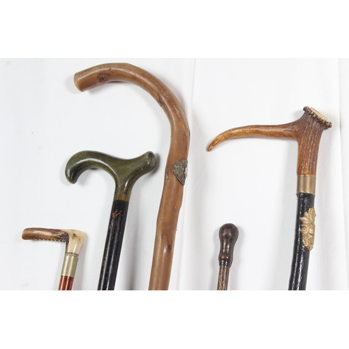 253 - Two vintage riding crops, a vintage horn handled walking cane and two others.