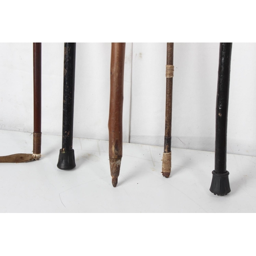 253 - Two vintage riding crops, a vintage horn handled walking cane and two others.