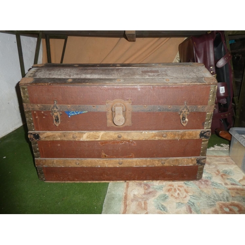 141 - An antique dome shaped trunk with wooden panels.