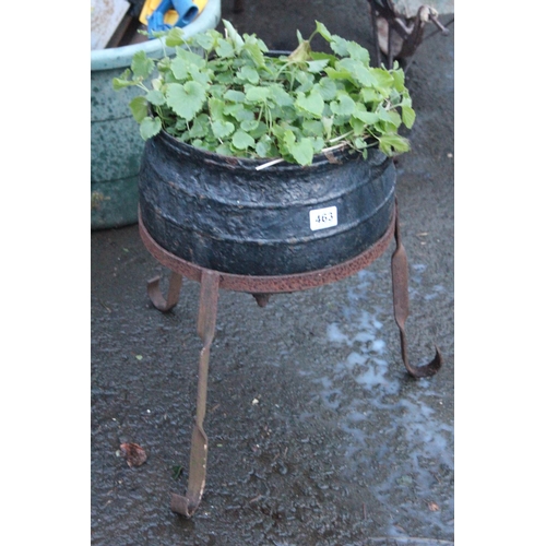 463 - An antique black pot on a cast metal stand.