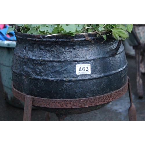 463 - An antique black pot on a cast metal stand.