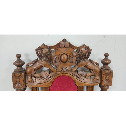 293 - An antique chair with intricate woodwork and lion motif designs.