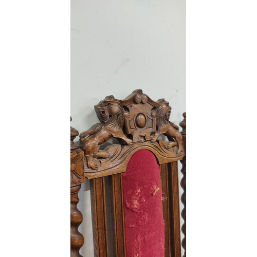 293 - An antique chair with intricate woodwork and lion motif designs.