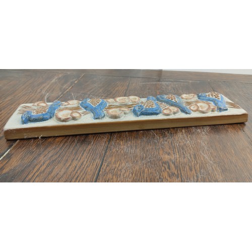 73 - A Marianne Stark pottery wall plaque of birds. 33x8cm.