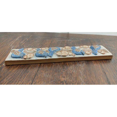 73 - A Marianne Stark pottery wall plaque of birds. 33x8cm.