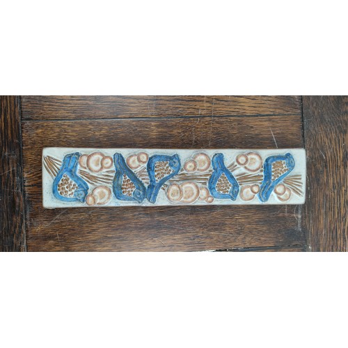 73 - A Marianne Stark pottery wall plaque of birds. 33x8cm.