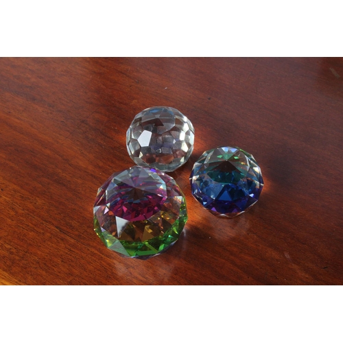 22 - Three rainbow crystal paperweights.