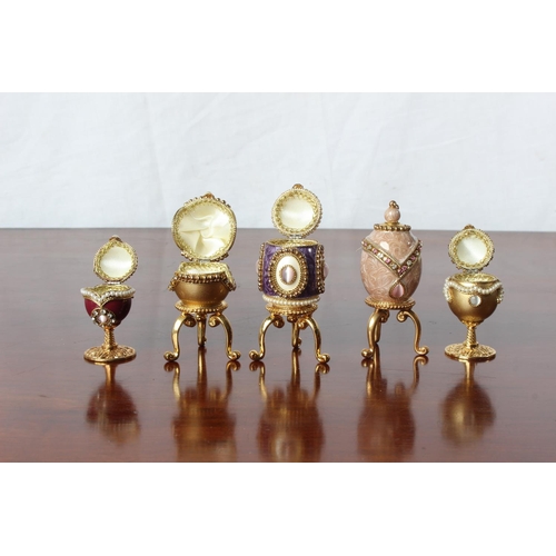 52 - A collection of five Faberge style egg shaped trinket/pill boxes.