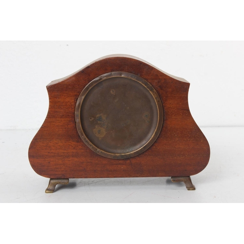 99 - An antique mahogany and inlay mantle clock on brass feet.