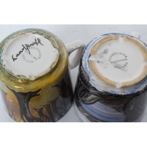 115 - A pair of Irish Carrigaline hand painted pottery mugs.