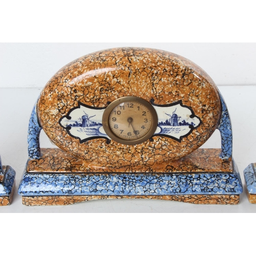 118 - An antique clock & garniture set in decorative ceramic case with Dutch scenes.