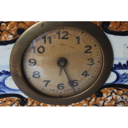 118 - An antique clock & garniture set in decorative ceramic case with Dutch scenes.