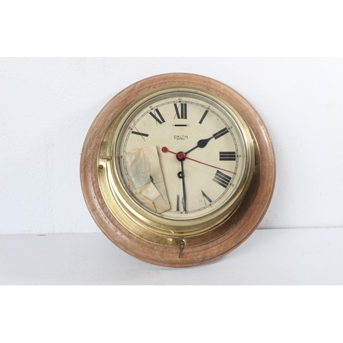 A stunning antique brass cased Smiths Astral ships bulkhead clock, mounted on wooden base.