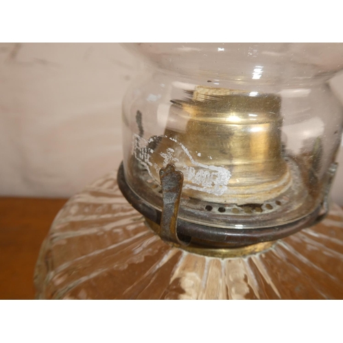 211 - An antique oil lamp with clear glass font on decorative cast iron base.