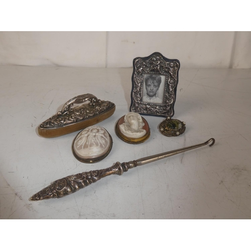 462 - An assortment of items, to include a silver button hook, vintage cameos and more.