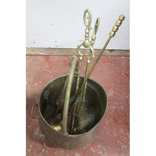 320 - An antique brass coal bucket and fireside companion set.