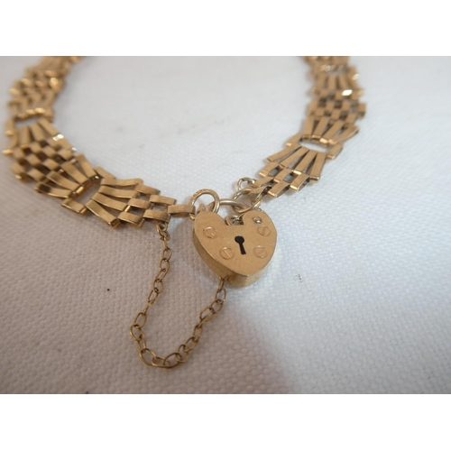 66 - A 9ct gold gate bracelet with padlock charm, weighing 5.21g.