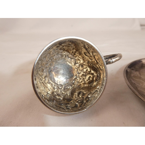 83 - A stunning antique Chinese Silver cup & saucer set, with decorative dragon design, weight 131g.