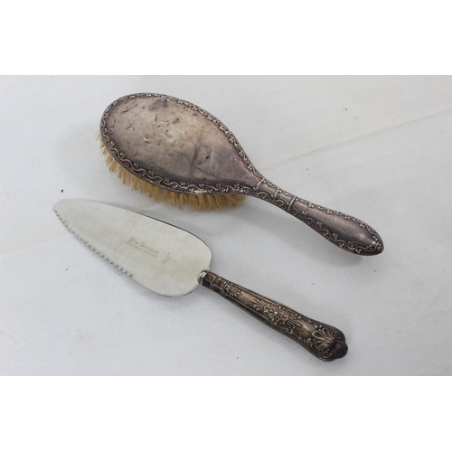 102 - A Sterling Silver backed hair brush and a Sterling Silver handled cake knife.