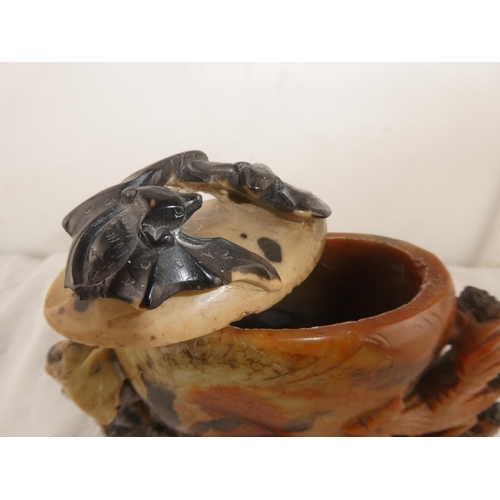 110 - An antique Oriental carved soapstone lidded pot decorated with a pig, bats and roosters.