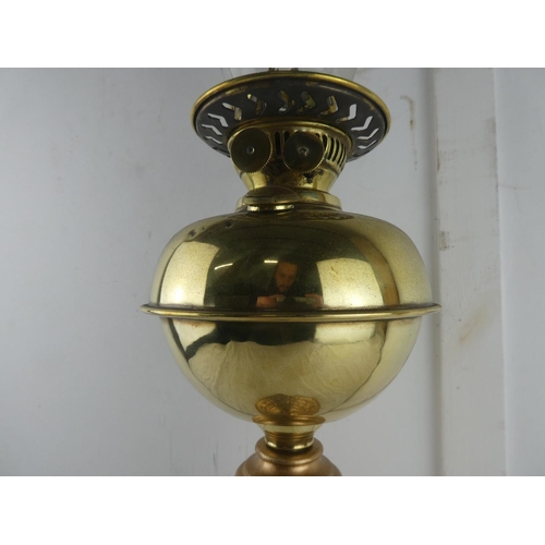 121 - A vintage brass oil lamp with gilt metal base, measuring 65cm tall.