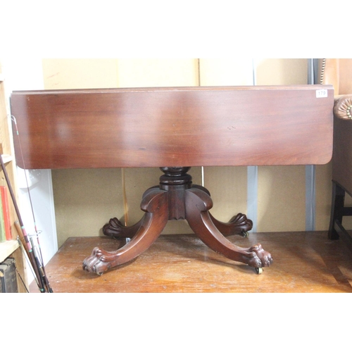 179 - An antique mahogany drop leaf dining table on centre pedestal with claw feet detail.