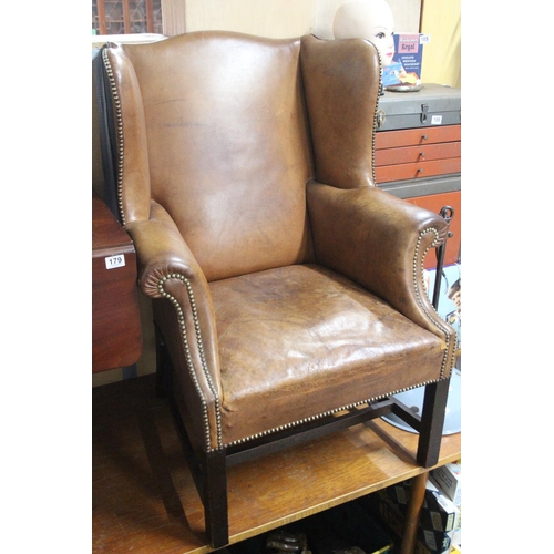 183 - A stunning antique leather upholstered winged backed armchair.