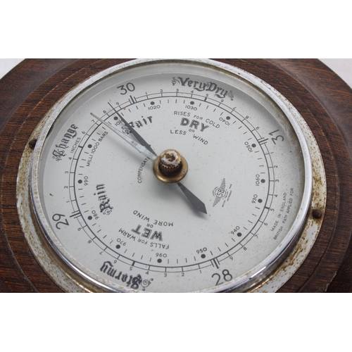 266 - An oak cased barometer in the style of a ships wheel.