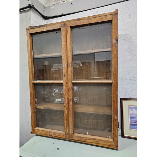 358 - A handmade pine bookcase with glazed doors.