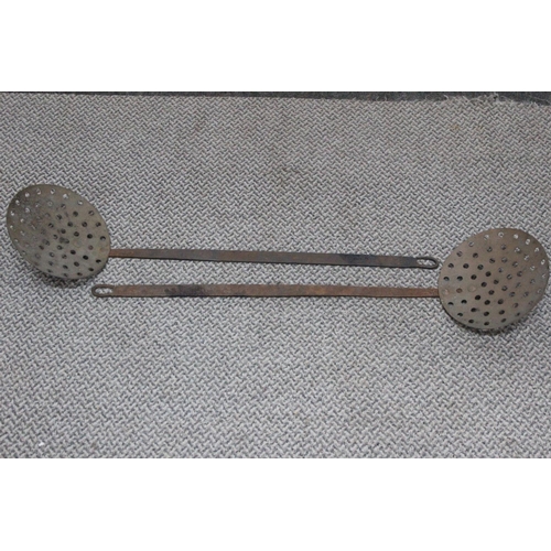 525 - A pair of antique long handled strainers. 79cm