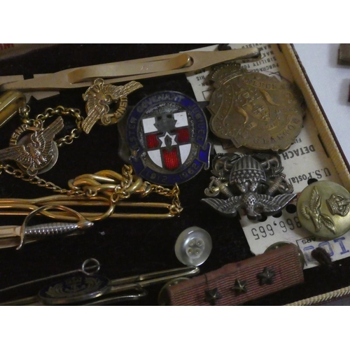 128 - An assorted lot of military badges and pins.