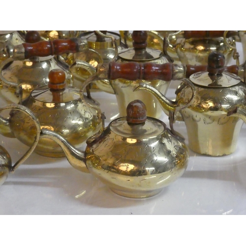 265 - A large lot of small brass teapots with wooden handles.