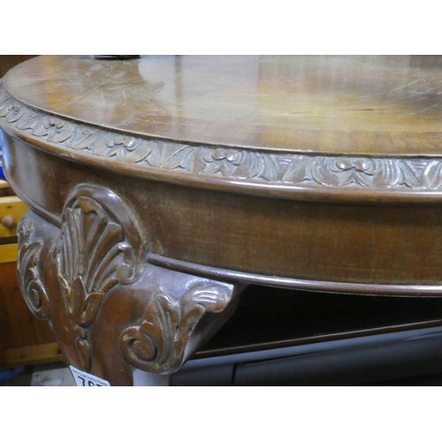 195 - A vintage circular mahogany coffee table with decorative carving.