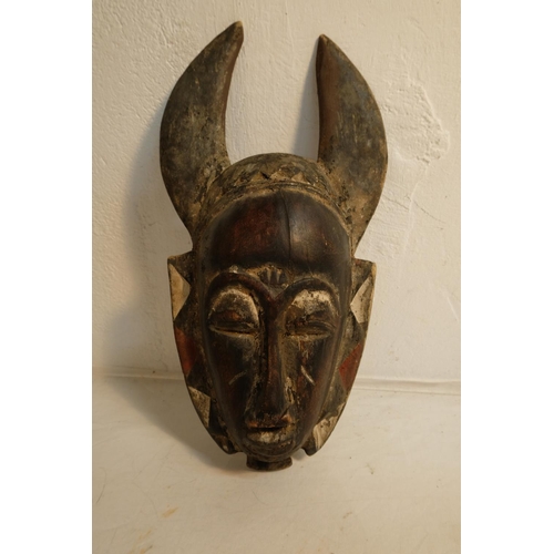 75 - A hand carved wooden tribal mask, measuring 36cm and wooden mask in the style of an animals head, me... 