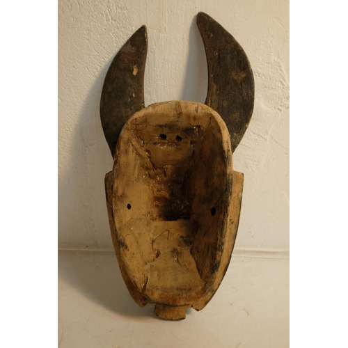 75 - A hand carved wooden tribal mask, measuring 36cm and wooden mask in the style of an animals head, me... 