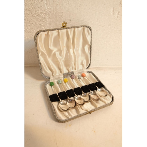 395 - A vintage cased set of coloured coffee bean spoons.